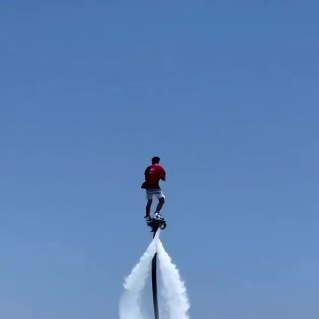 A flyboard rider hovering above the bay on a jet of water