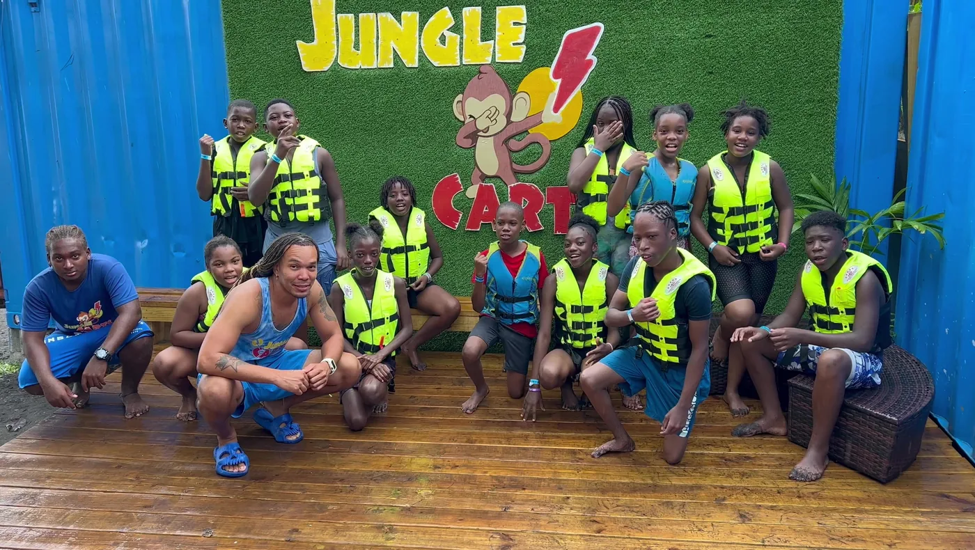A full group in life vests with the Jungle Carts crew, in front of the painted wall at Mero