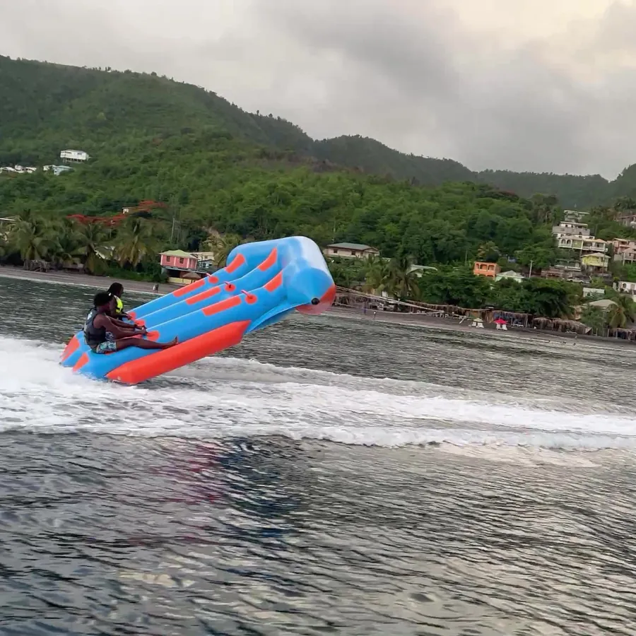 The raft ride under tow, riders holding on through the wake